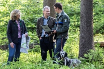 Förster spricht im Wald mit einem Waldbesitzer und einer Waldbesitzerin 