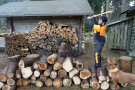 junger Mann in Arbeitskleidung hackt Holz