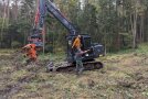 Förster und Baggerfahrer vor Bagger im Wald