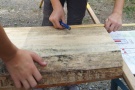 Kinderhände übertragen den Bauplan für den Steckstuhl auf die Fichtenbohle