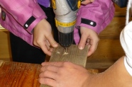 Kinderhände bauen einen Vogelnistkasten zusammen